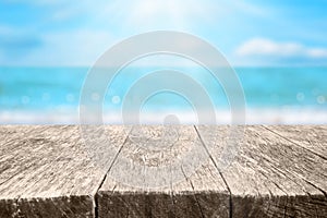 Wood table over blurred blue sea and beach background in sunny summer day. Background with copy space for product display