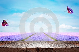 Wood table over blurred spring flowers background. Template for product display
