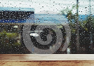 Wood Table with Raindrop on Window in Rainy Day, for background