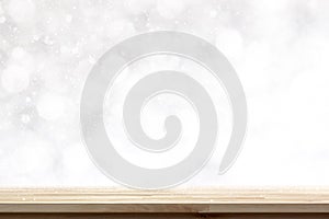 Wood table top on abstract white bokeh background with snow