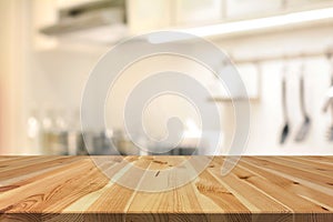 Wood table top (as kitchen island) on blur kitchen interior back