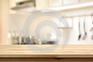 Wood table top (as kitchen island) on blur kitchen interior back