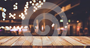 Wood table top Bar with blur light bokeh in dark night cafe