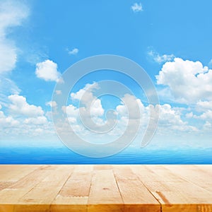 Wood table top on blue sea water and bright summer sky background