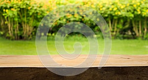 Wood table top on blur abstract green,flower from garden