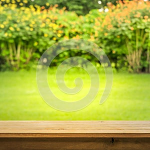 Wood table top on blur abstract green,flower from garden