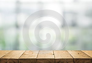 Wood table top on blur of abstract window glass
