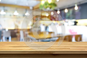 Wood table top on blur background of coffee shop (or restaurant) interior