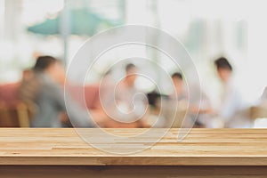 Wood table top on blur background of people in coffee shop