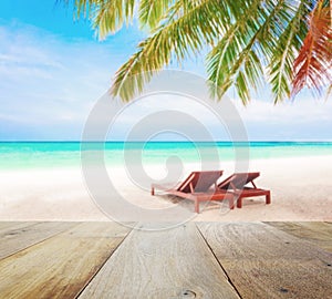 Wood table top on blur beach background with beach chairs