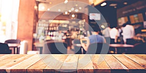 Wood table top with blur coffee shop,cafe background.