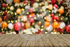 Wood table top on blur colorful Christmas tree and gold bokeh background with snowfall