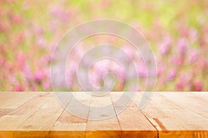 Wood table top on blur flower garden background