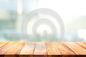 Wood table top on blur glass window wall building background.