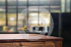 Wood table top on blur kitchen or cafe room background .For mont