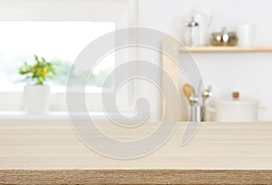 Wood table top with blur kitchen window and shelves background