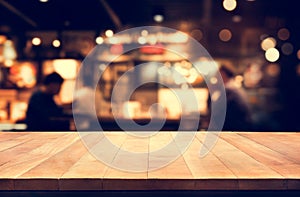 Wood table top with blur light bokeh in night cafe background