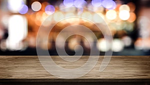 Wood table top with blur nightclub bar counter with bokeh light