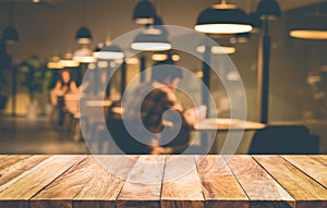 Wood table top with blur of people in coffee shop