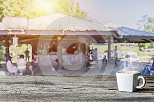 Wood table top with blur of people in coffee shop