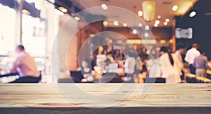 Wood table top with blur of people in coffee shop or cafe,restaurant