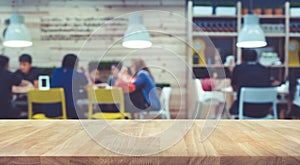 Wood table top with blur of people in community cafe shop background