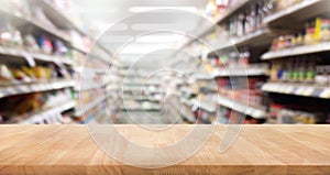 Wood table top on blur of supermarket product shelf background. photo