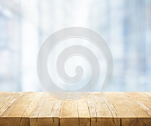 Wood table top on blur white glass wall background