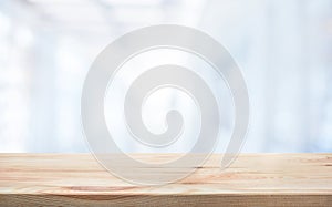 Wood table top on blur white glass wall background form office