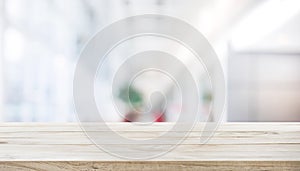 Wood table top on blur white glass wall background form office