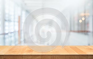 Wood table top on blur white glass wall background form office building