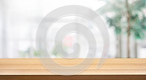 Wood table top on blur white glass wall background form office building photo
