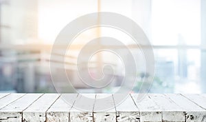 Wood table top on blur white glass window background form office