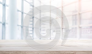 Wood table top on blur white glass window background form office