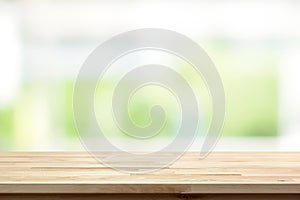 Wood table top on blur white green kitchen window background