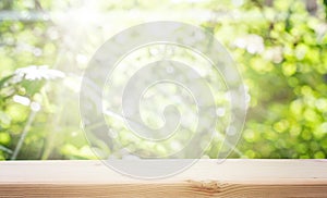 Wood table top on blur white green natural abstract background from tree branches