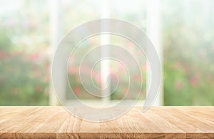 Wood table top on blur of window with garden flower background