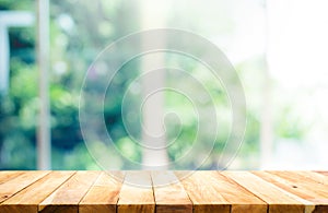 Wood table top on blur of window with garden flower background