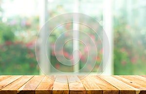 Wood table top on blur of window with garden flower background