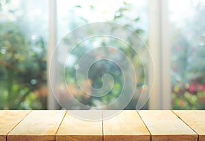 Wood table top on blur of window with garden flower background