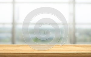 Wood table top on blur window glass, restaurant wall background.For montage product display or design key visual layout