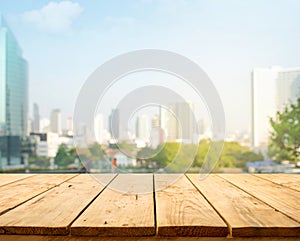 Wood table top on blur window glass,wall background with city view.For montage product display or design key visual