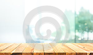 Wood table top on blur window glass,wall background with city view.For montage product display or design key visual