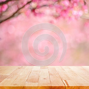 Wood table top on blurred background of pink cherry blossom flowers