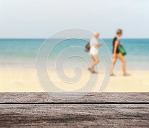 Wood table top on blurred blue sea and white sand beach