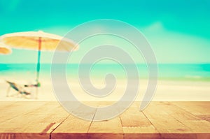 Wood table top on blurred blue sea and white sand beach background, vintage tone