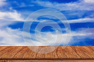 Wood table top on blurred blue sky background