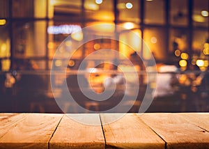 Wood table top on blurred of cafe restaurant with light gold