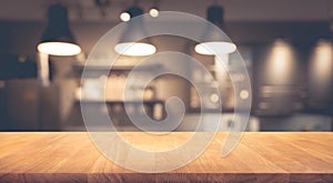 Wood table top on blurred of counter cafe shop with light bulb background