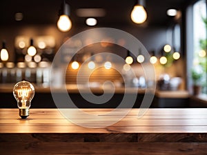 Wood table top on blurred of counter cafe shop with light bulb Background